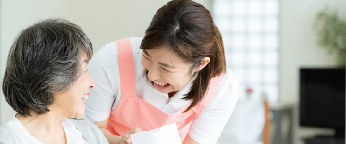 笑顔を向け合う職員と高齢女性