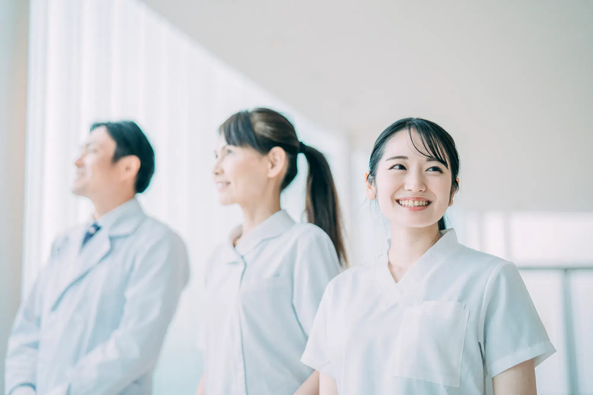 白衣を着た女性が3人並んでいる