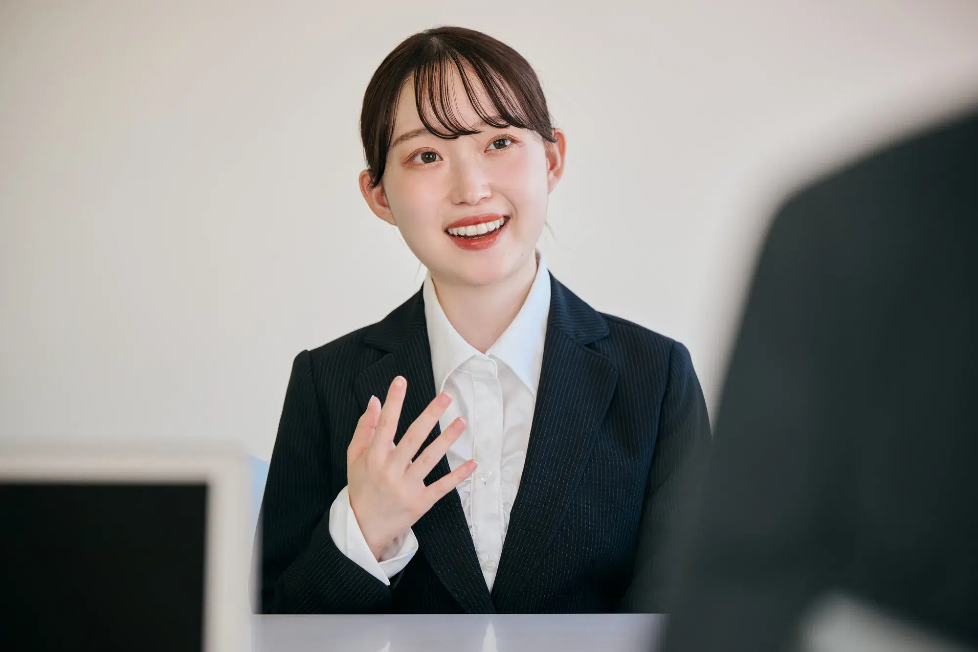 黒いスーツを着た女性が説明
