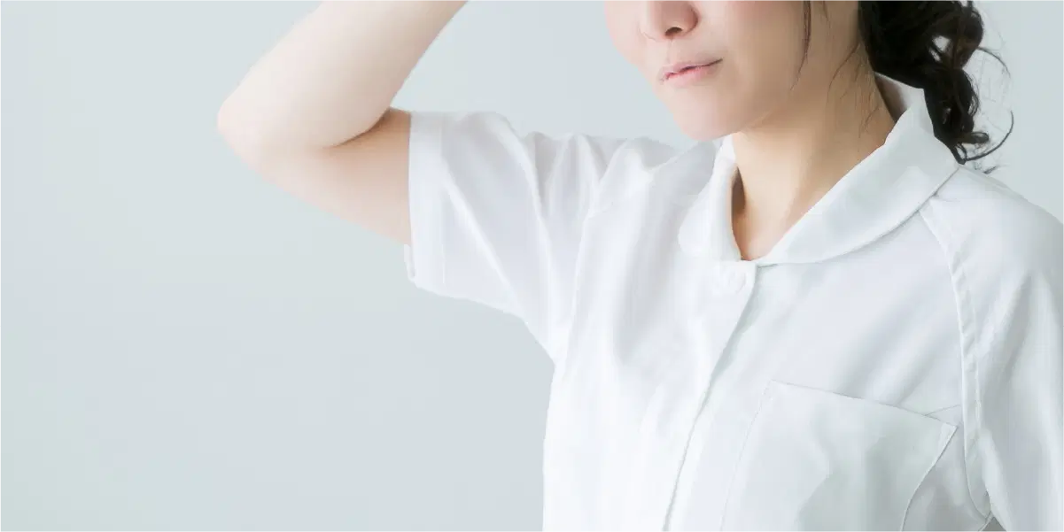 白い半袖の服を着た女性の鼻から下と上半身が写っている