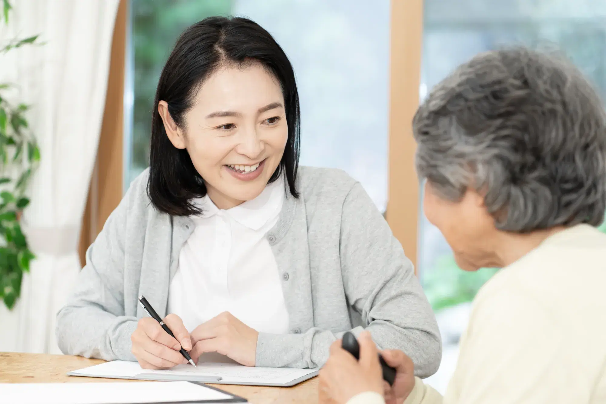 高齢女性と話をする職員の女性