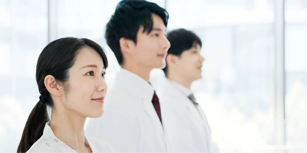 真っ直ぐ前を見ている白衣を着た男女が三人