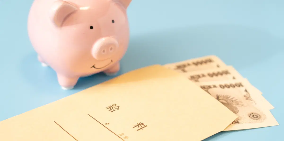 ぶたの貯金箱と給料袋からお札が出ている様子