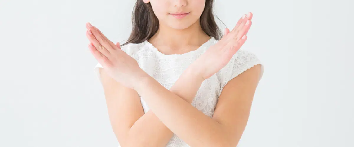 少女が手でバツの形を作ってる