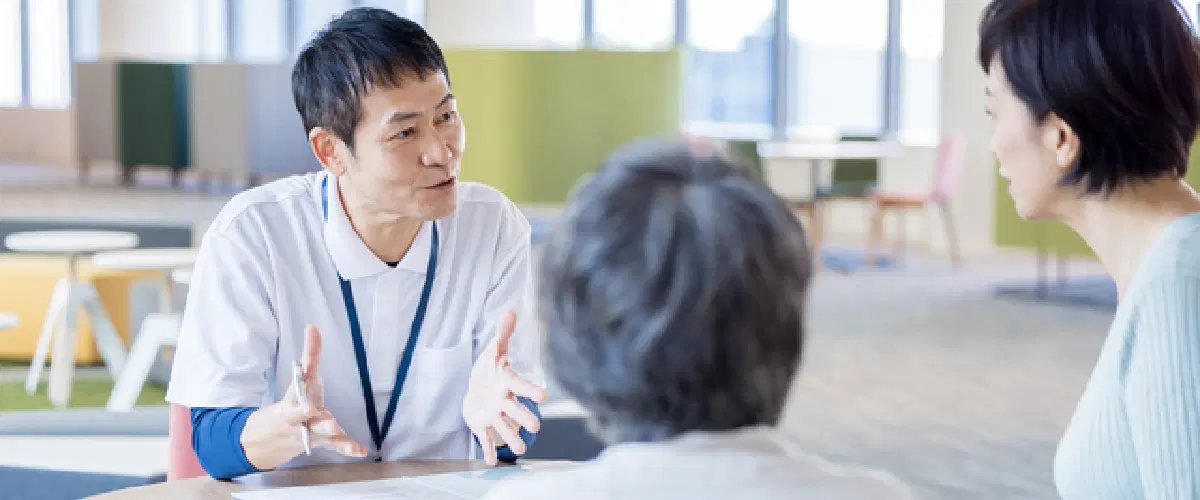 相手にジェスチャーを持ちながら説明をする男性職員