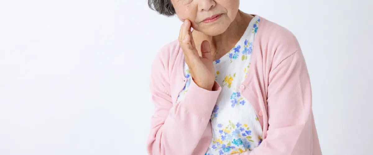 複雑の表情で悩んでる高齢者の女性