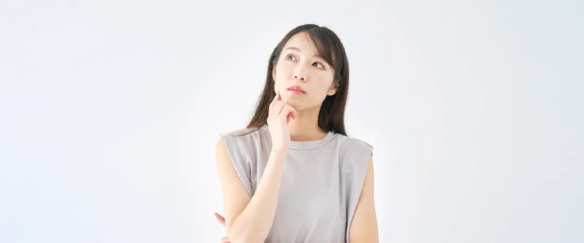 左上を見ながら悩んでる女性