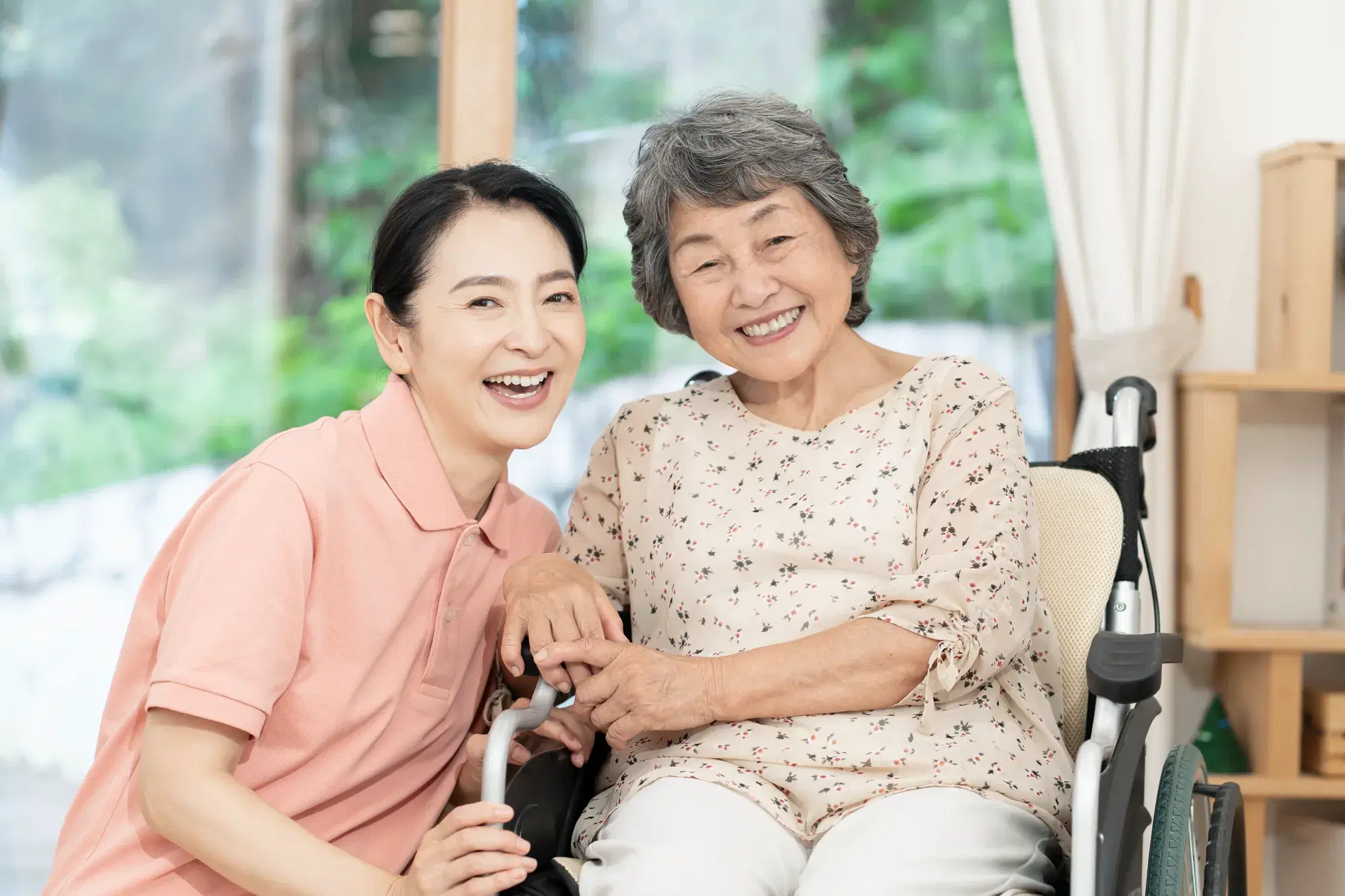 車椅子の高齢女性と支援員の女性