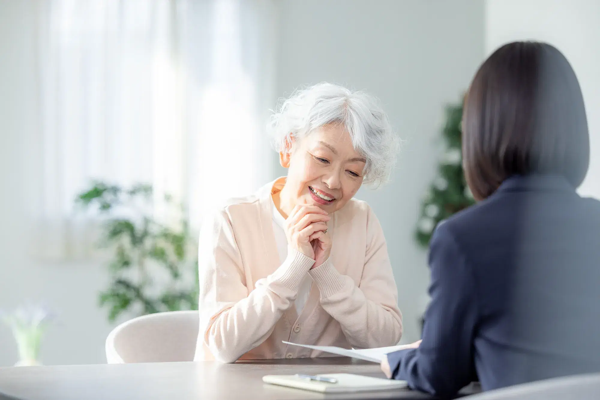 白髪の年配の女性と黒色のスーツを着た女性