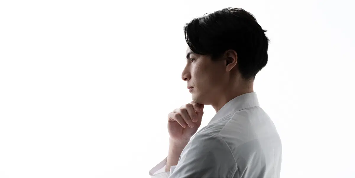 首を傾げ考える様子のスーツの男性