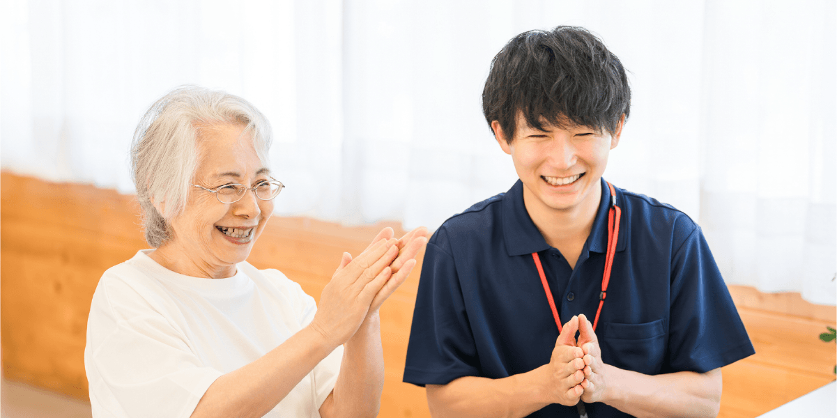 おばあさんと男性の職員さんが手を合わせている