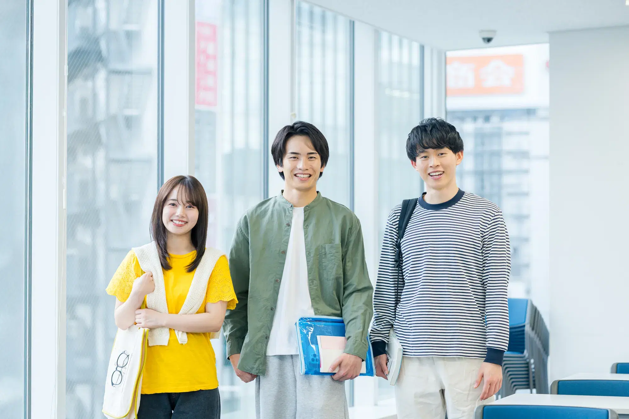 黄色の服を着た女性と薄緑色の服を着た男性と青と白の縞々の服を着た男性