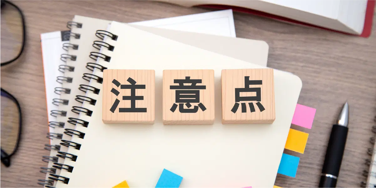 注意点と書かれた木の立方体が3つ白いノートの上に置かれている