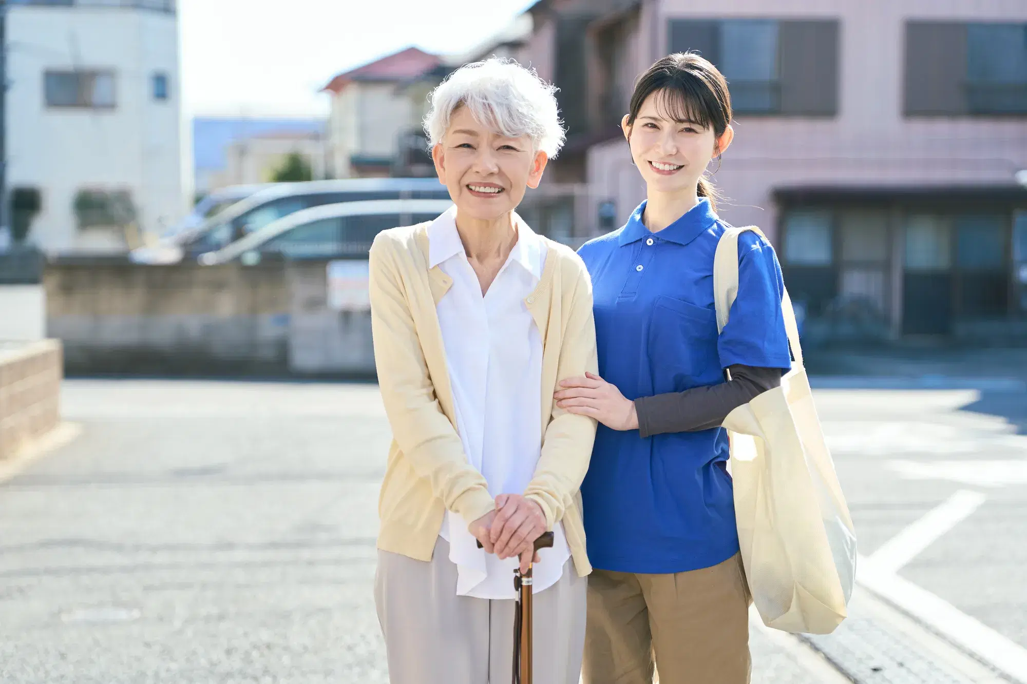 青い服を着た女性が薄黄色の服を着た女性の介助