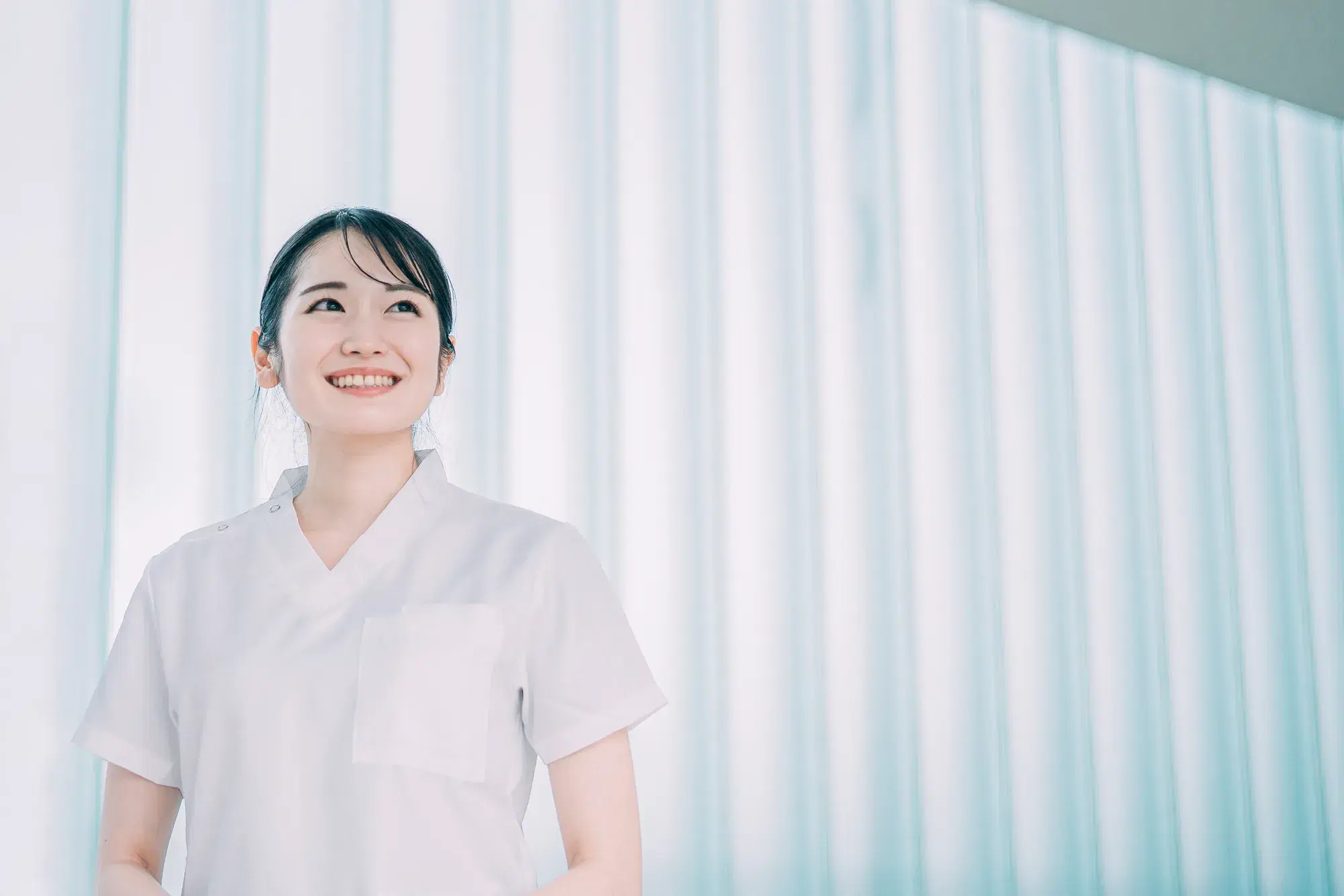 白衣を着た女性が微笑んでいる