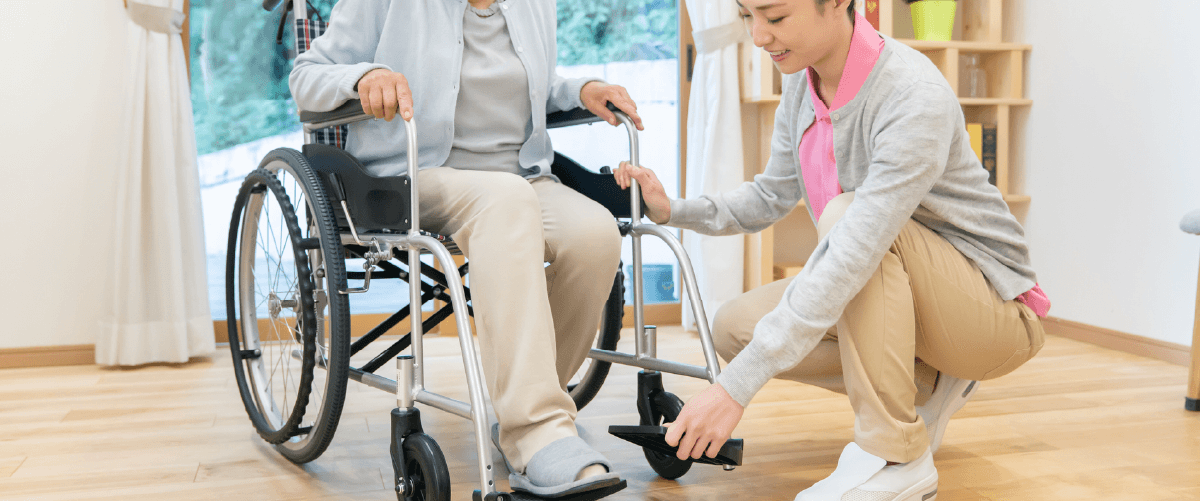 来る車椅子の介助を行う職員女性
