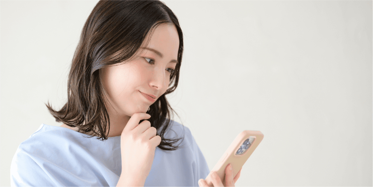 スマホを見ながら悩んでいる女性