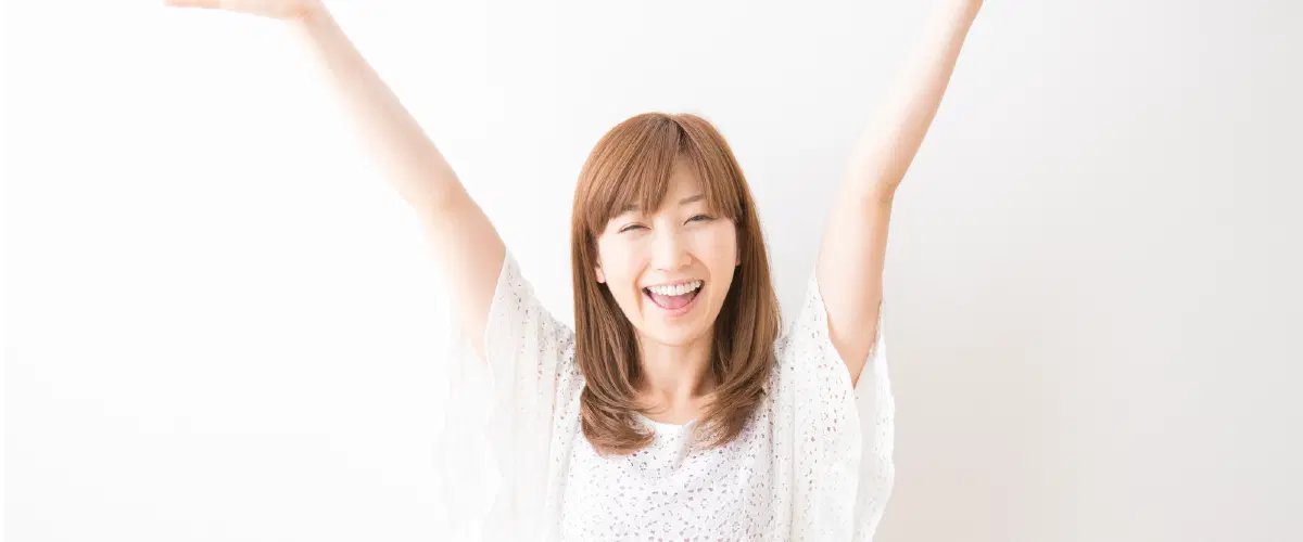 両手を挙げて喜んでいる様子の女性