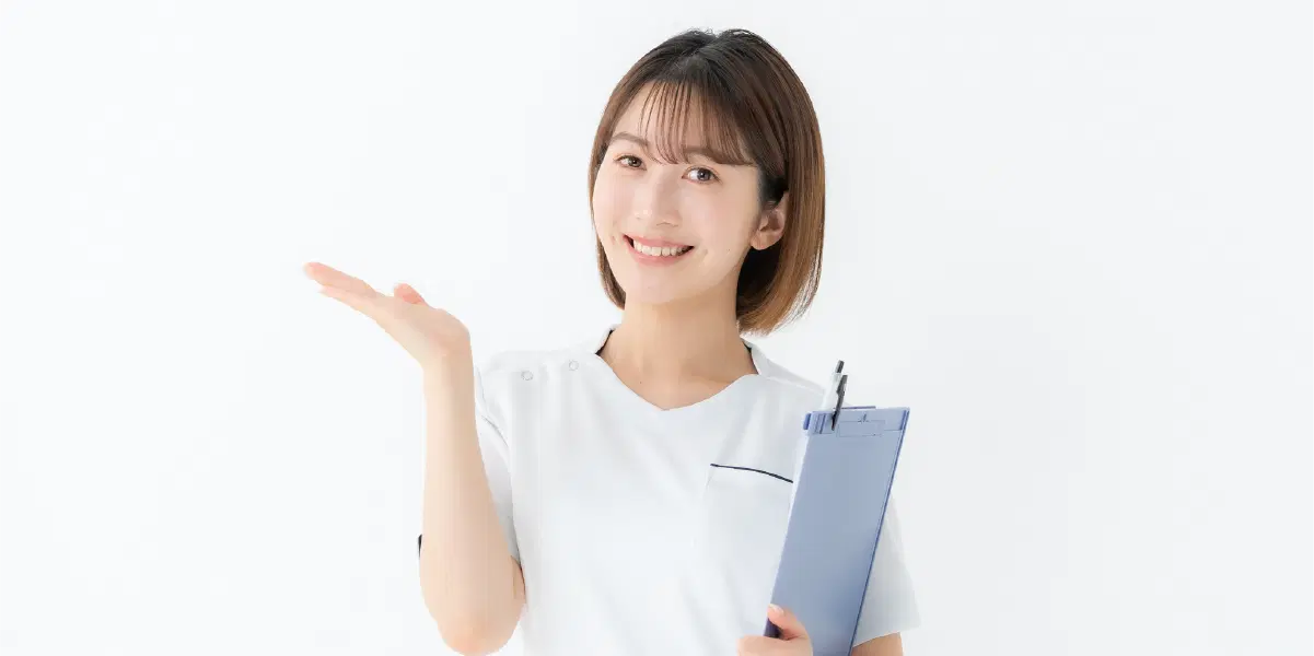 バインダーを片手に笑顔を向ける職員の女性