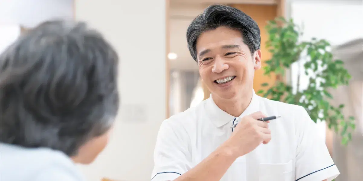 笑顔で利用者と話す介護職員の男性