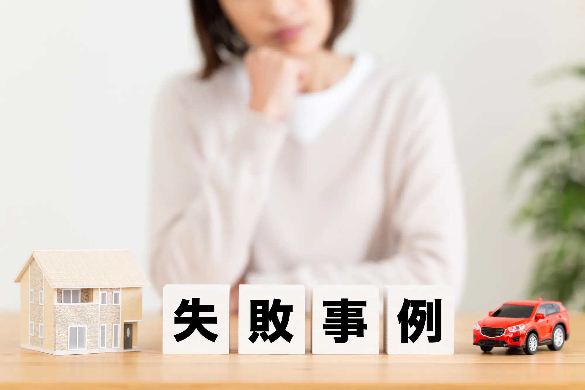 白い服を着た女性と失敗事例と書かれた木材ブロック