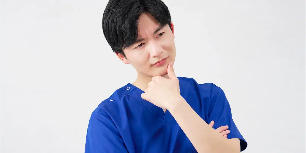 首を傾げ考える様子の医療職員の男性