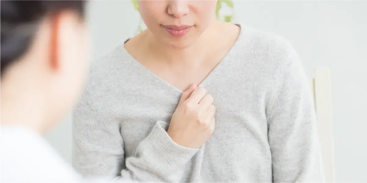 胸元に手を当てる女性とその人の話を聞く女性