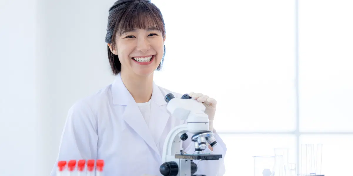 顕微鏡を使う笑顔の女性