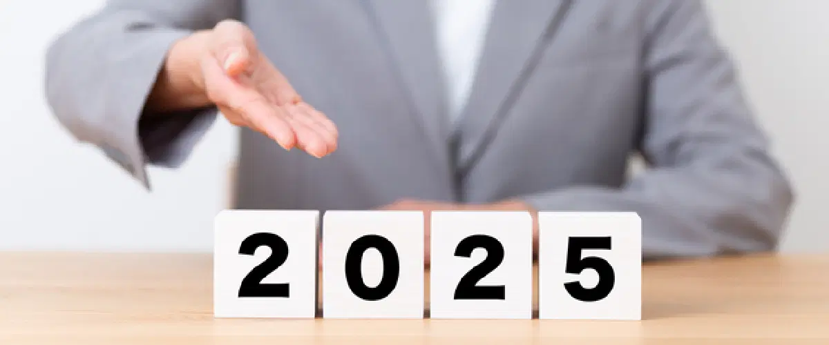 2025のブロックを差し出してるスーツの人物