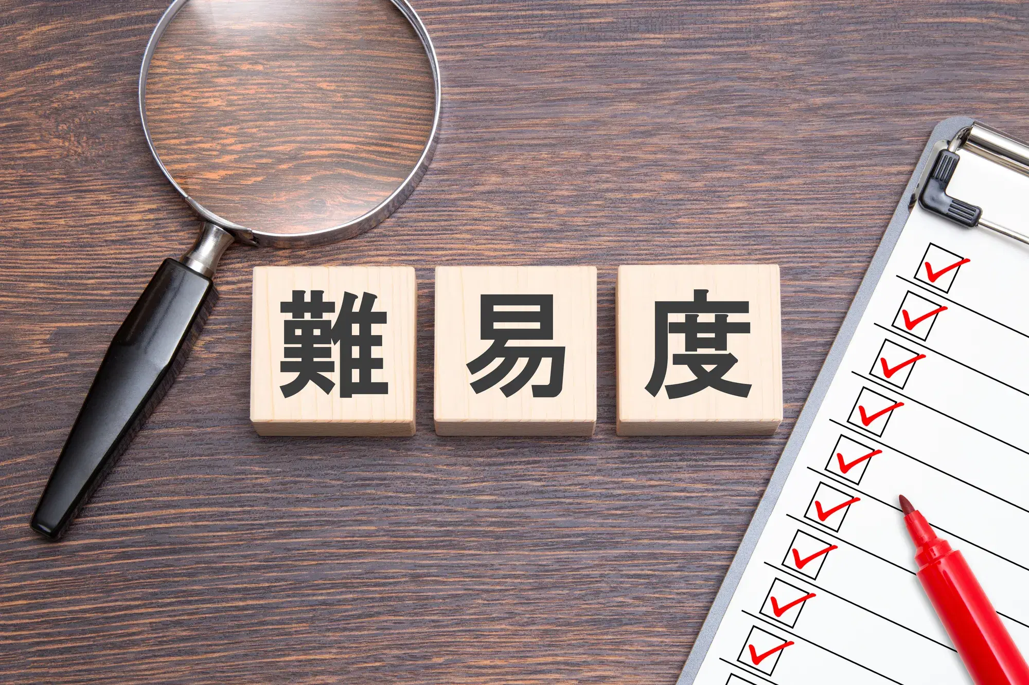 難易度と書かれた木の立方体が三つ並び、横に虫眼鏡と赤ペンが置かれている。