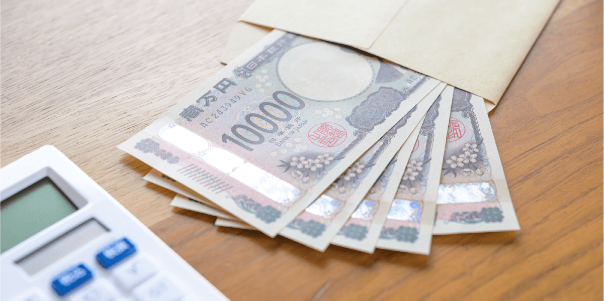 一万円札が封筒から何枚か出ていて、横に計算機が置いてある。