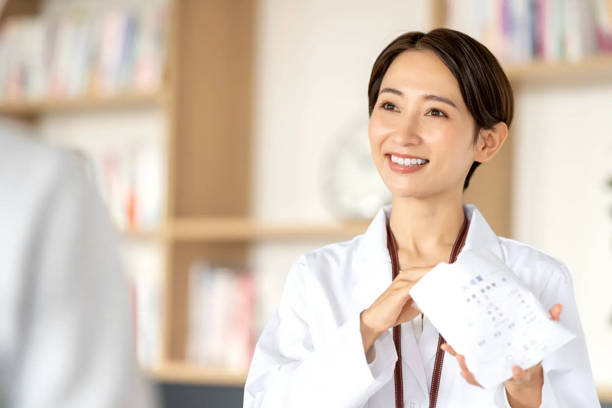 薬剤師の女性が話しながら薬の袋に手を入れている