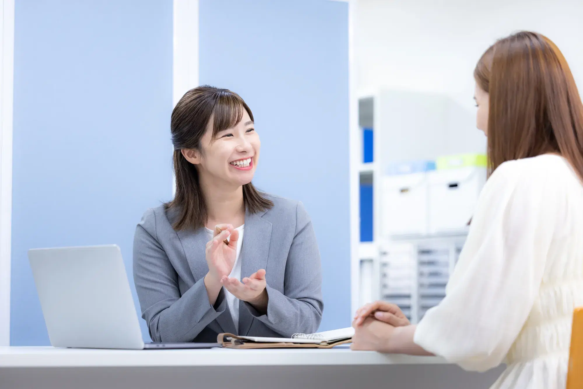 鉛筆を持ち笑顔で説明する女性