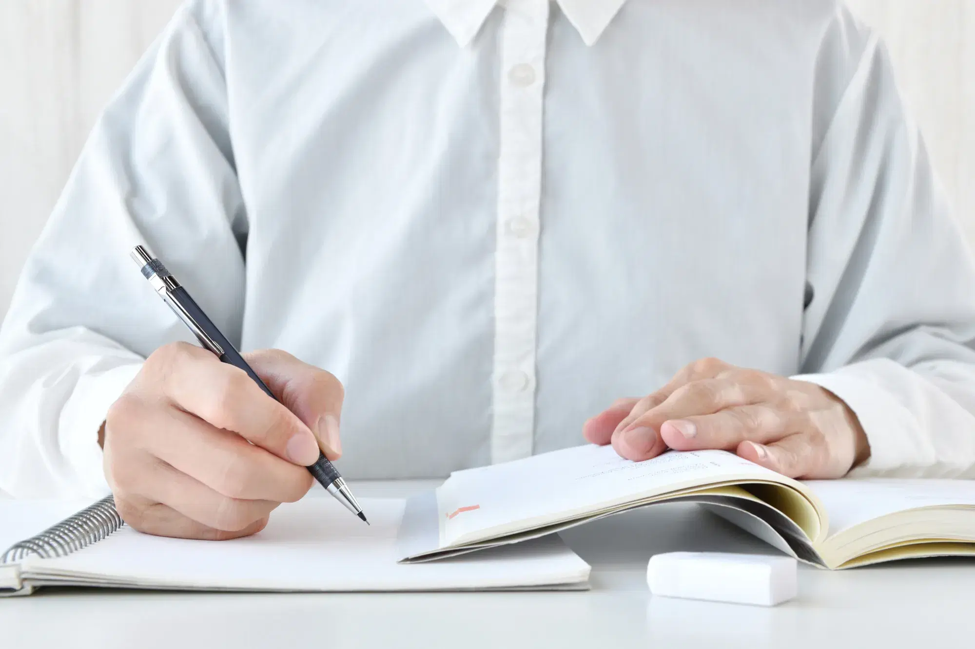 白いシャツを着た人が勉強している。