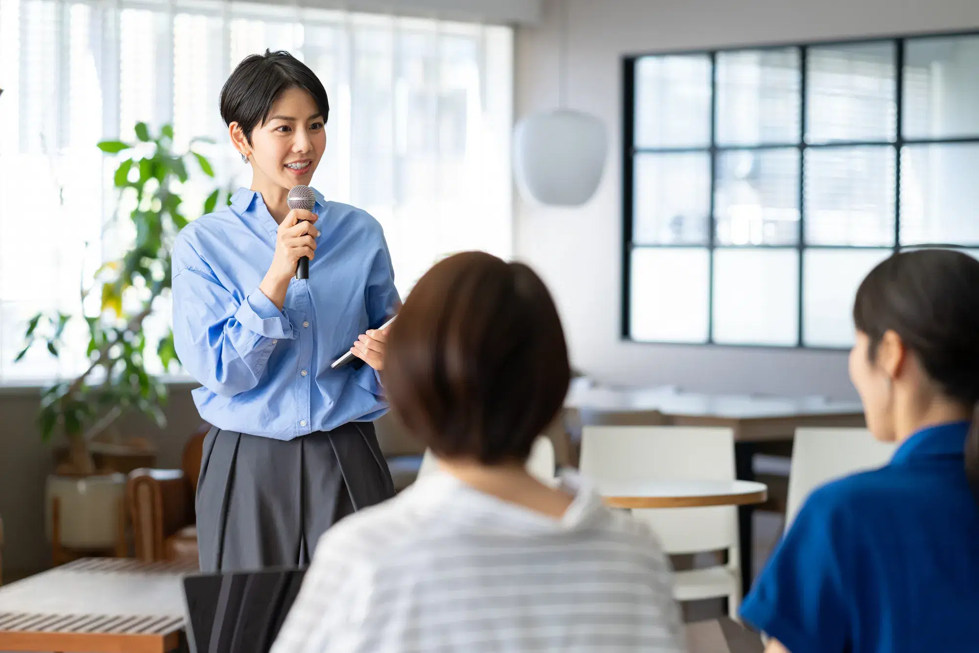 青い服を着たマイクを持った女性
