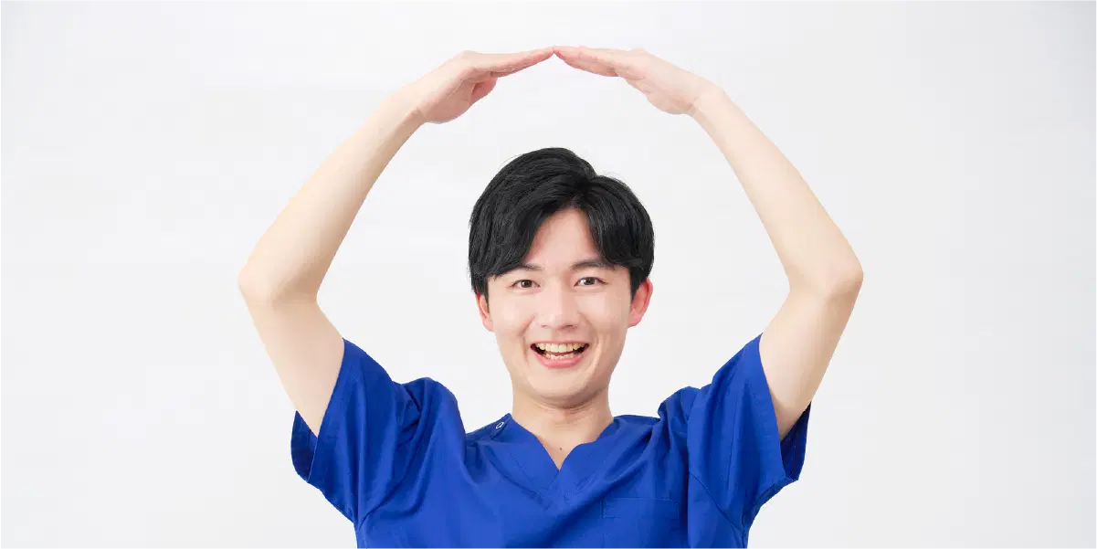 青い服を着た男性が手で大きな丸(〇)を作って笑っている。