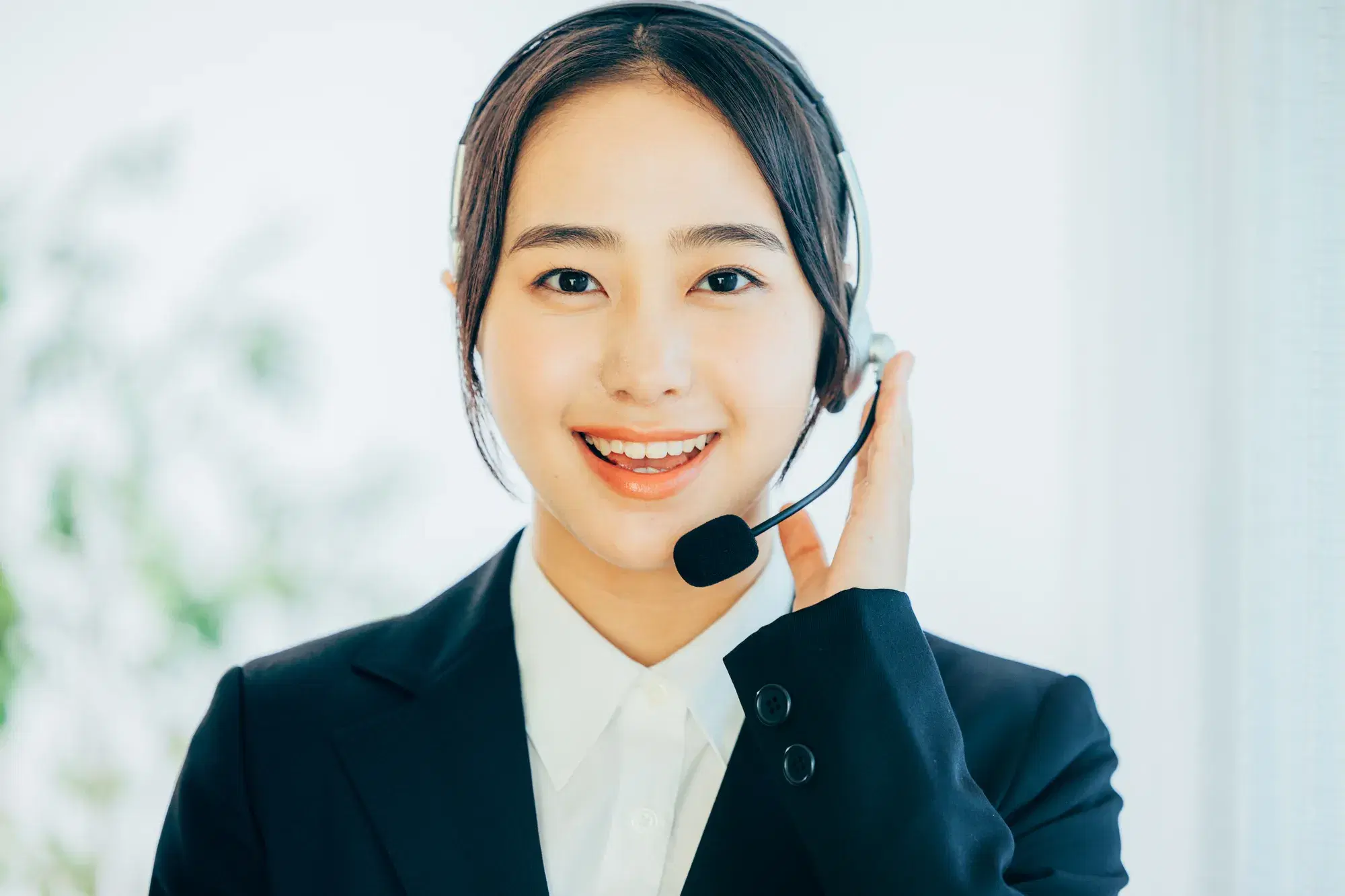 黒いスーツを着た女性がインカムをつけて対応