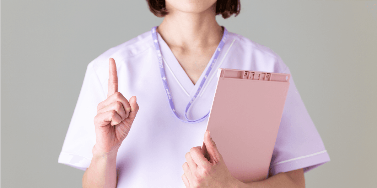 女性がバインダーを持って人差し指を立てている。