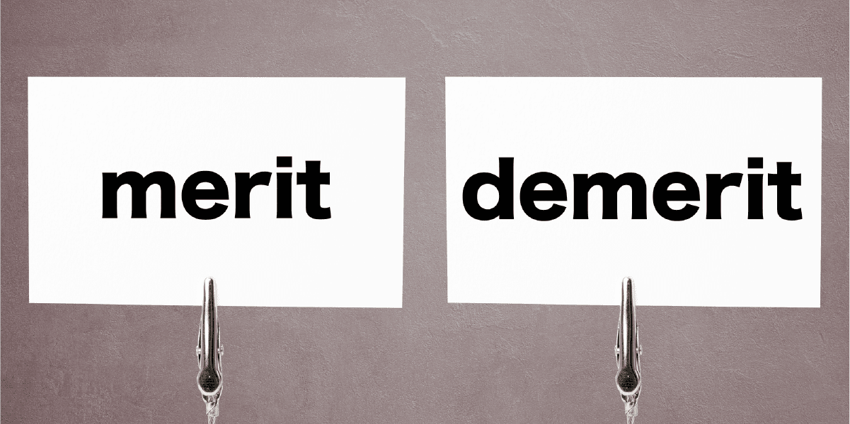 メリット(merit)とデメリット(demerit)と書かれた白い紙が二枚並んでいる