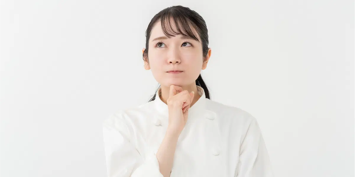 顎に右手を当て悩んでいる女性