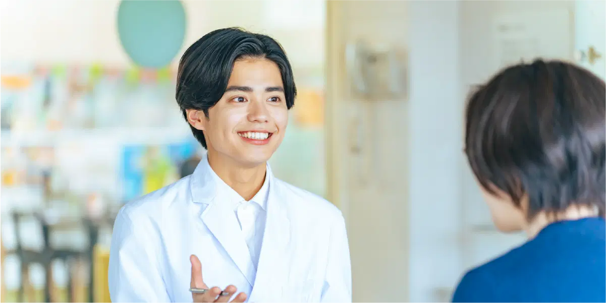 白衣を着ている男性が笑顔で話している