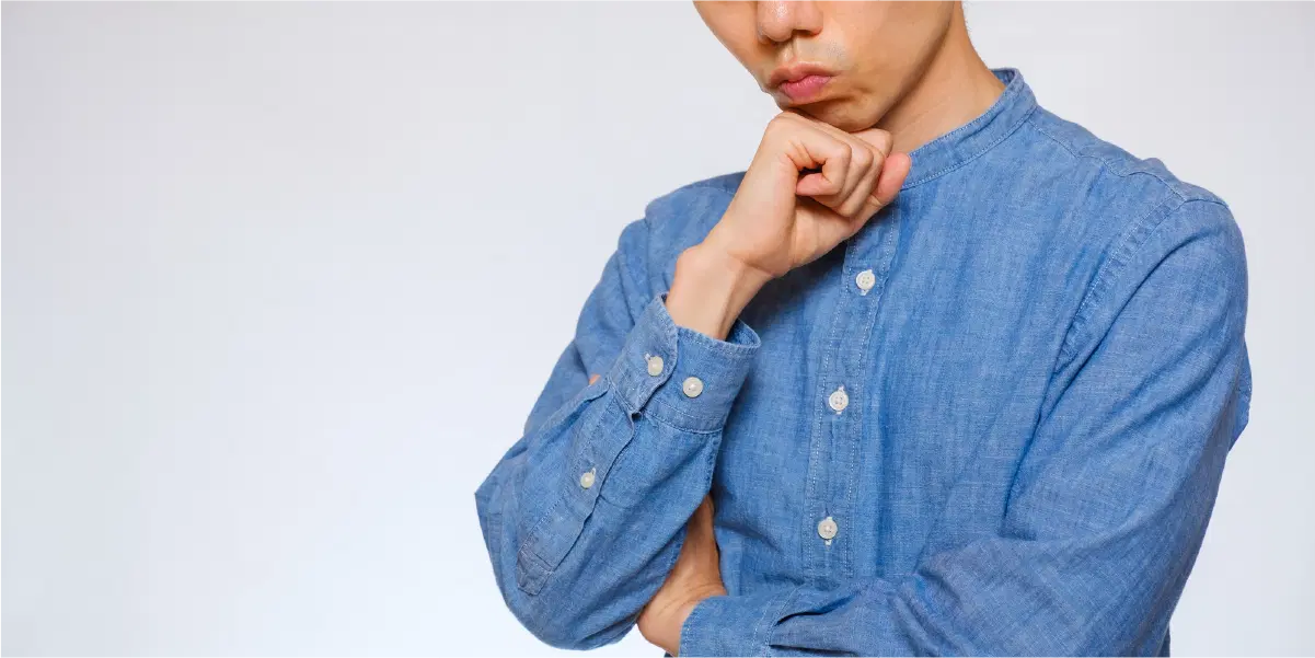 腕を組み何かを考える様子の男性