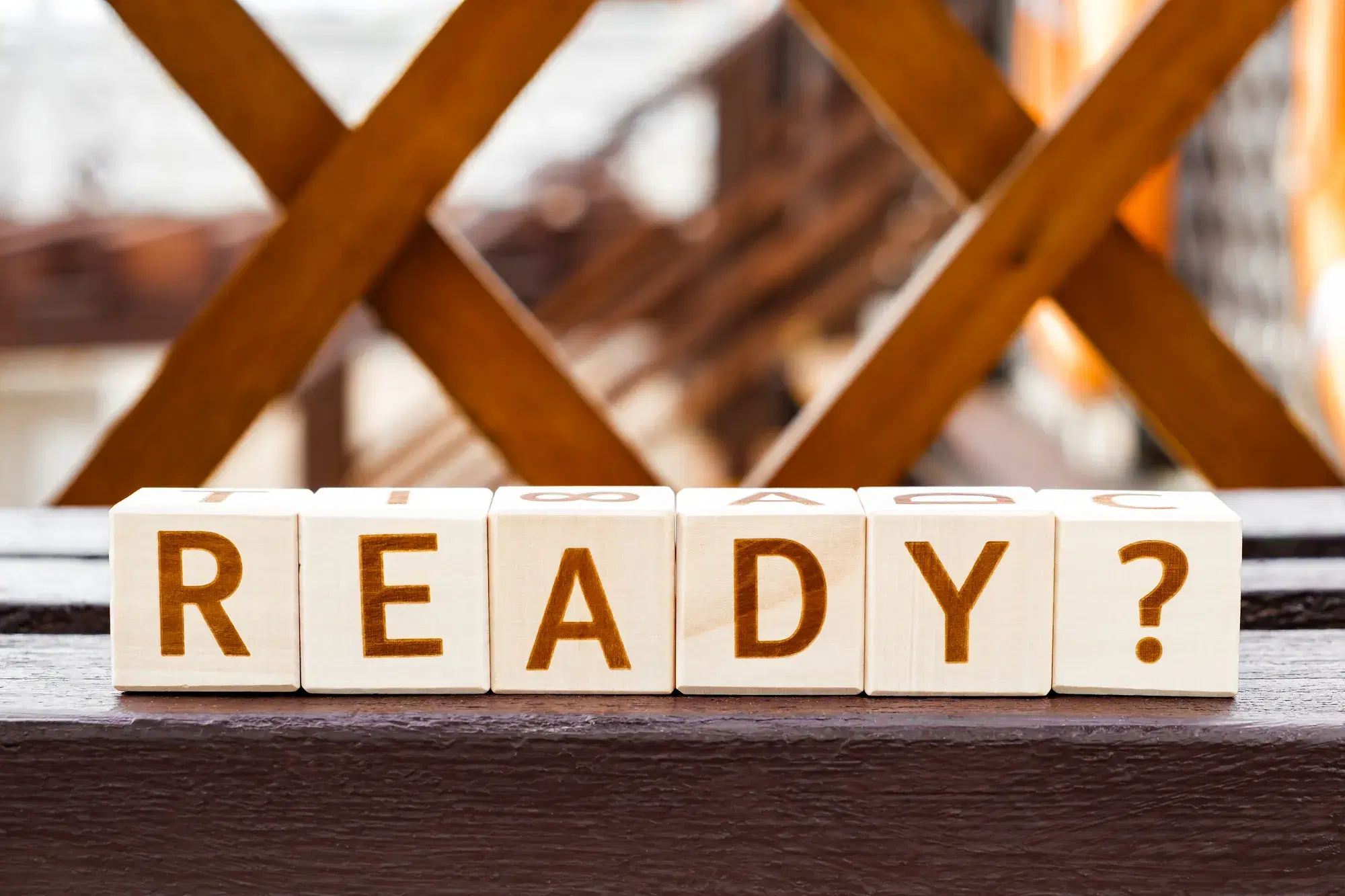 木製のフェンスを背景に「READY?」という文字が並べられた木製ブロックが写っている。