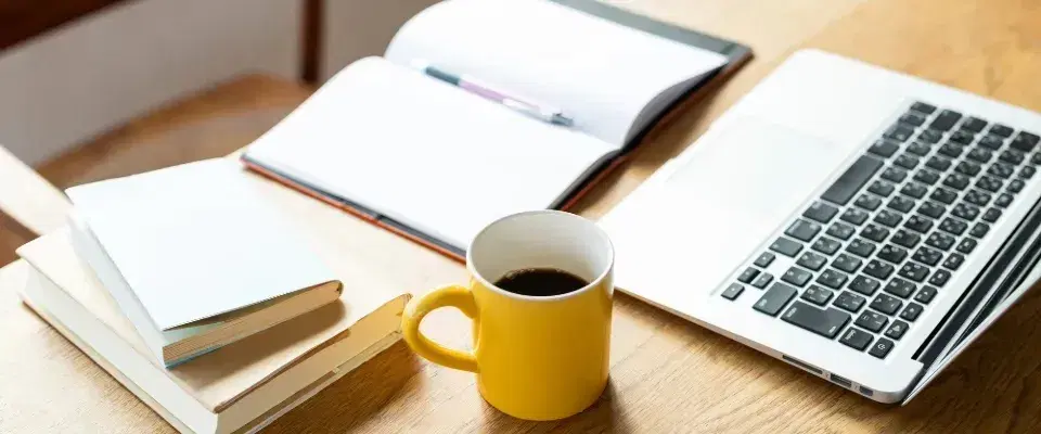 パソコンの横でコーヒーブレイクする様子