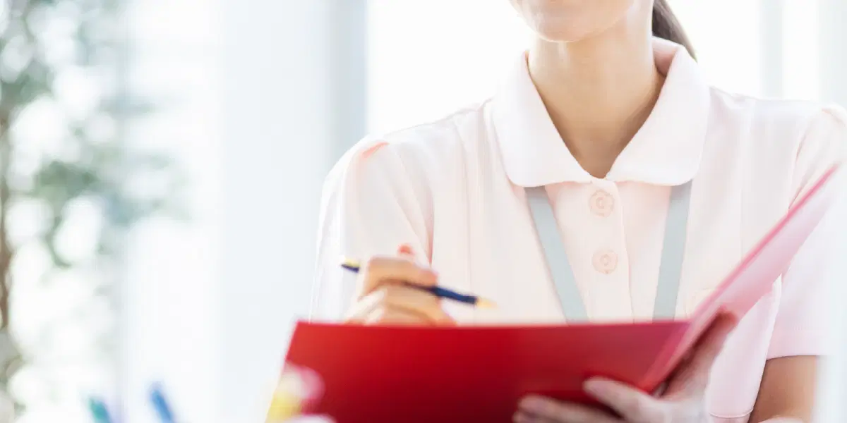 バインダーに書き込みをする職員の女性
