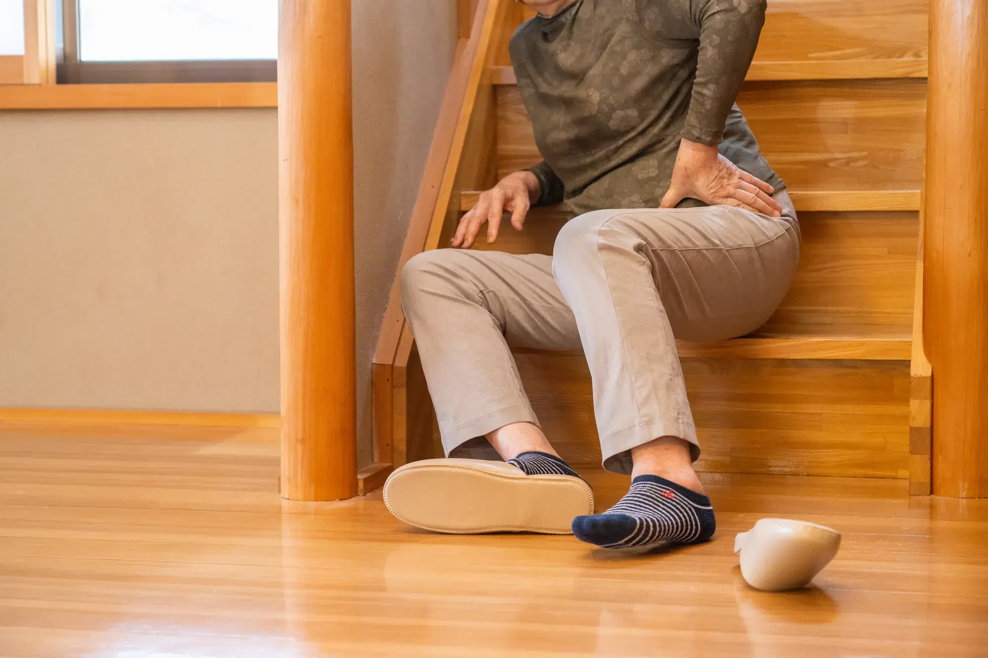 木の階段で座り込む緑色の服を着た人間