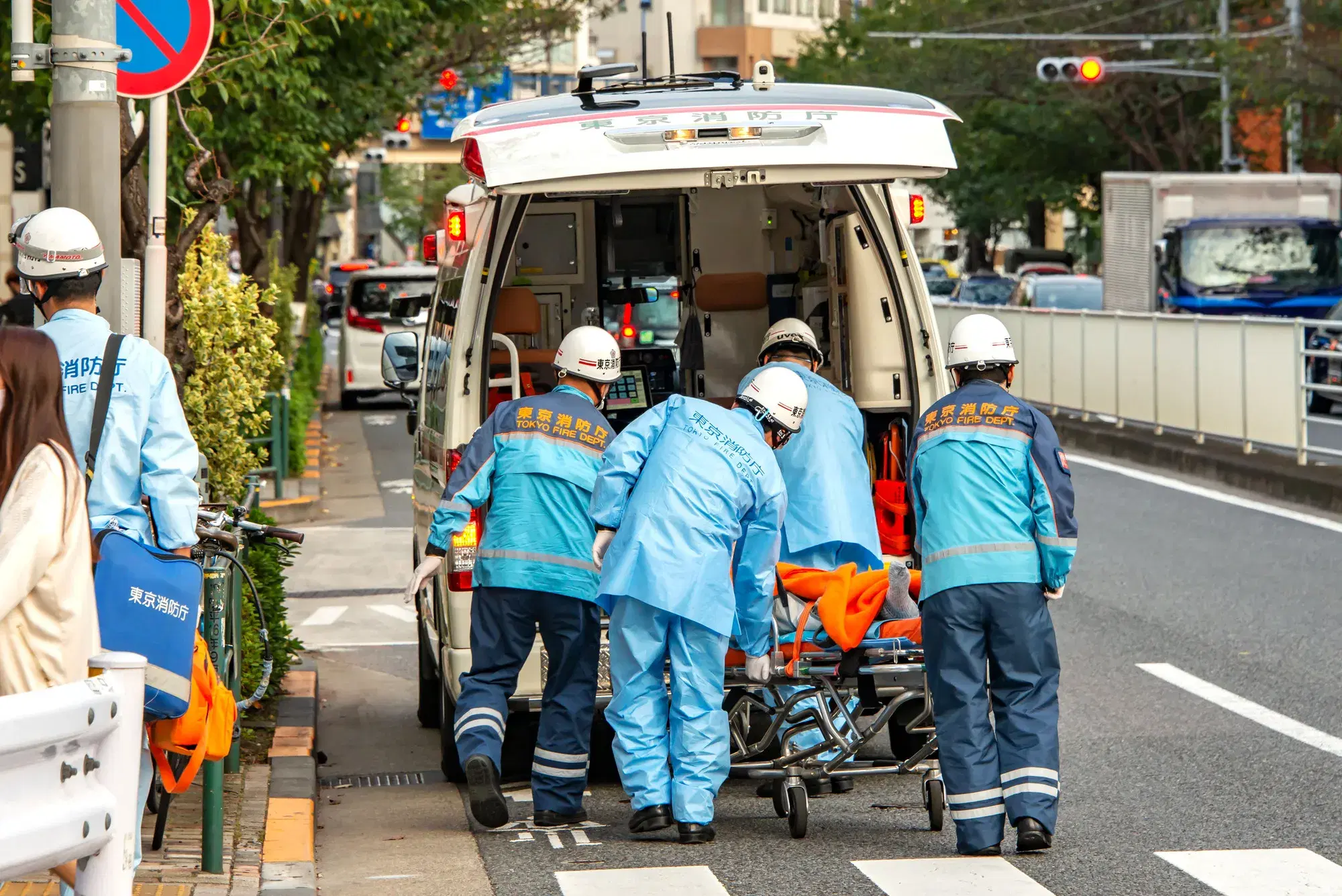 救急車の中に搬送される患者と水色の服を着た救急隊員