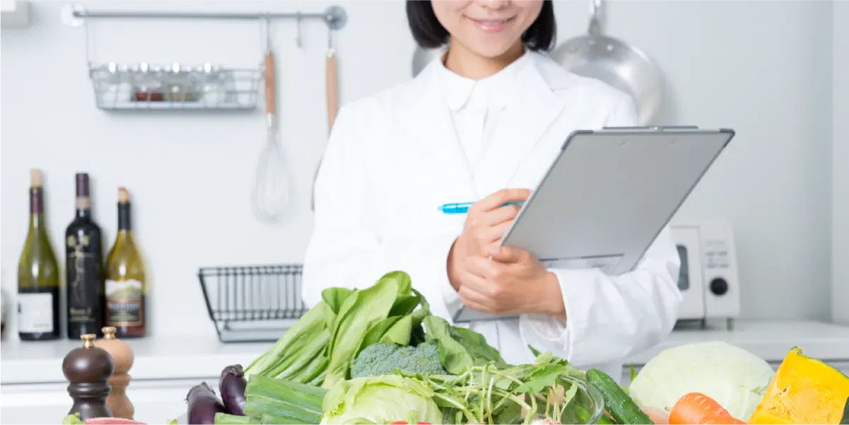 野菜や肉などの食材を見ながら、チェックしている女性