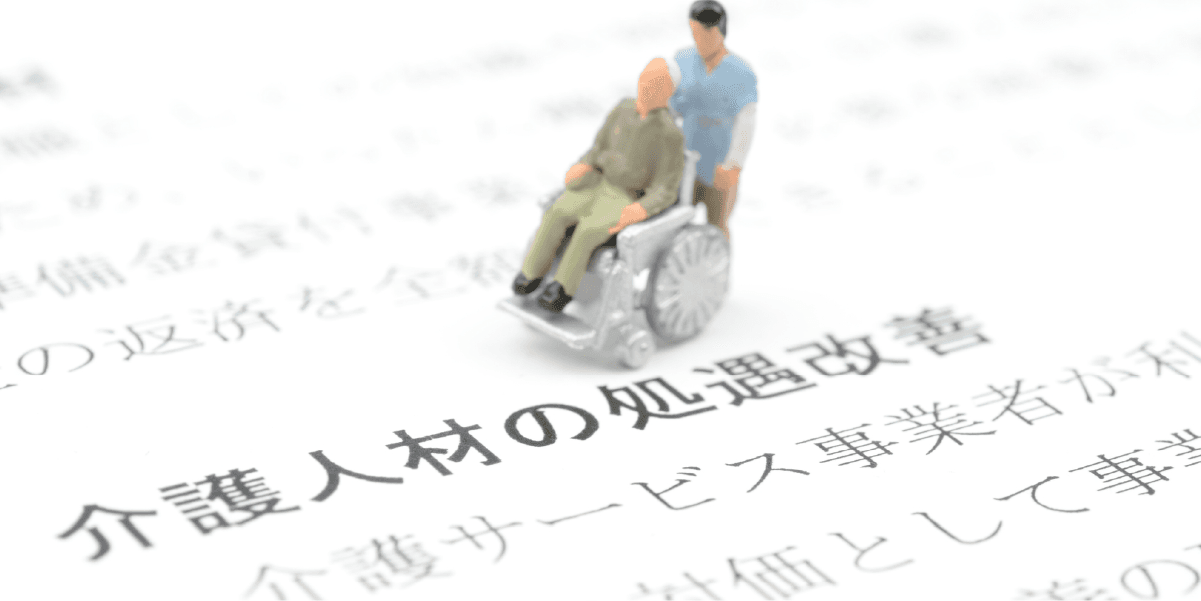 介護人材の処遇改善と車椅子のミニチュア人形