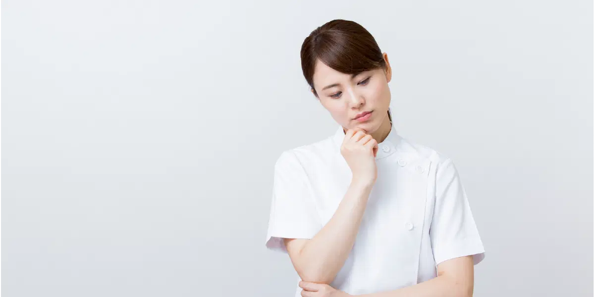顎に右手を当て悩んでいる女性